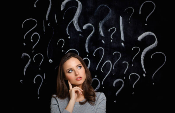 Young girl with question mark on a gray background Brand Keyword vs Non-Brand Keyword