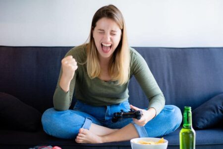 Young woman playing video games on sofa