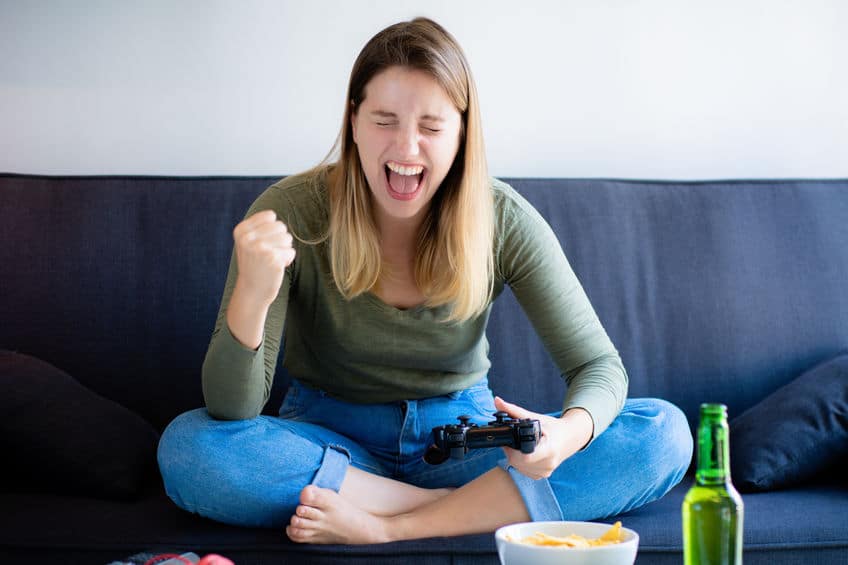 Young woman playing video games on sofa